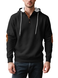 Close-up of geometric knit fabric with hoodie drawstrings and button placket detail