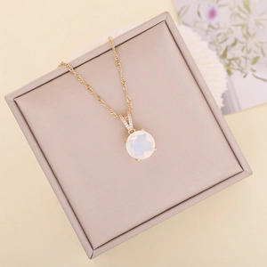 Faceted glass opal pendant necklace in gold finish displayed on a beige jewelry gift box