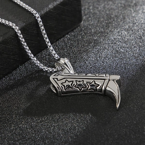 Macro detail of a polished silver cowboy boot pendant with embossed star motifs