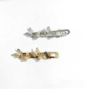 Detail of hollow butterfly hair clips with sparkling rhinestones in gold and silver finish