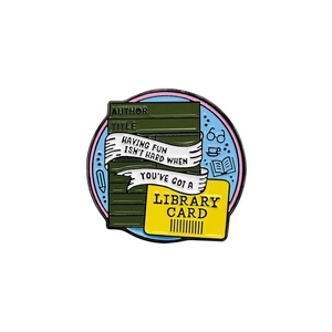Detailed close-up of a round enamel library card brooch with colorful books and quotes