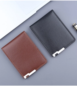 Detail of slim leather card holders in brown and black with pebbled texture and metal corners