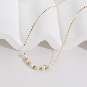 Elegant gold stainless steel necklace featuring natural white pearls and gold bead accents