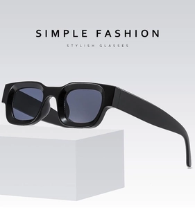 Detail of square concave frame sunglasses in matte black finish on geometric props