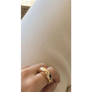 Close-up of a minimalist gold plated dome ring with a high-polished mirror finish