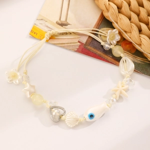 Dettaglio della collana oceano boho con conchiglia, stella marina e ciondolo pesce
