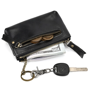 Close-up of black leather coin purse with double zippers, key ring and metal clasp