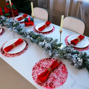 Detail of red sequin placemat with gold spiral napkin ring and festive cedar wreath