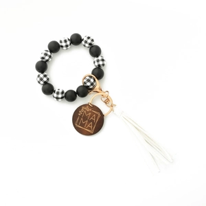 Detail of beaded keychain bracelet with leopard print beads, white tassel and MAMA wood charm