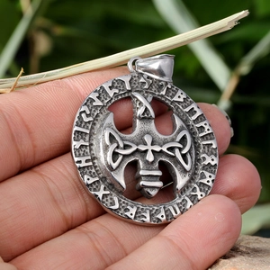 Vintage silver round pendant necklace with celtic raven and cross on green background