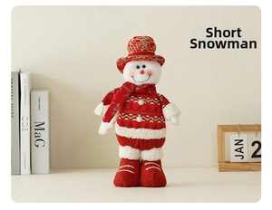 Detail of plush Christmas snowman figurine with red gold-patterned hat and knit sweater