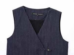 Detailed view of dark blue pinstripe vest label showing size S and fabric texture