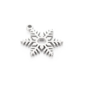 Pendentif flocon de neige en acier inoxydable poli avec boucle sur fond blanc