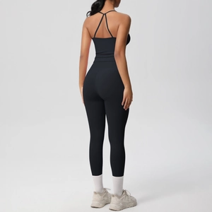 Detail of cross-back yoga bra and high-waisted leggings in matte black sports fabric