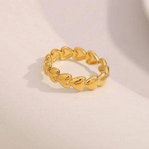 Detailed close-up of a 18K gold plated heart open ring on a soft textured background