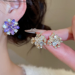Detail showing elegant purple flower stud earrings and crystal geometric ear studs