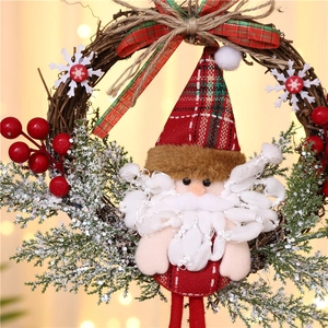 Close-up of Santa Claus plush on a rustic rattan wreath with red berries and snow pine