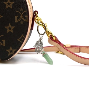 Hamsa Hand keychain with green hexagonal crystal pillar on patterned round bag