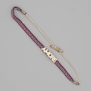 Detail of red woven Amore bracelet with diamond accents and boho geometric patterns
