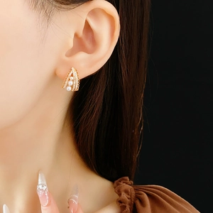 Detail of vintage gold lace earrings with pearls and crystals worn by a model