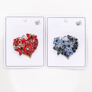 Detailed view of luxury rhinestone butterfly heart brooches in red and blue colors