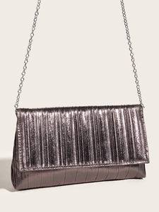 Dettaglio ravvicinato della pochette da sera a pieghe metalliche con catena in argento