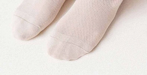 Gros plan de chaussettes en maille beige montrant le tissu respirant et la pointe