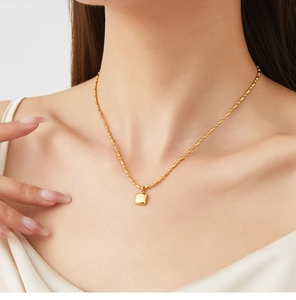 Détail d'un collier plaqué or 18 carats avec pendentif carré et chaîne à billes