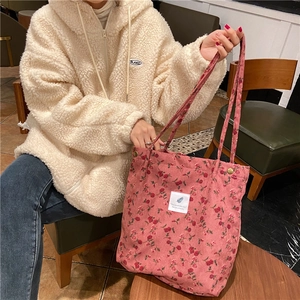 Detailed macro of pink corduroy tote bag featuring floral patterns and textile label
