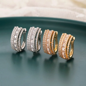 Chic gold and silver plated ear hoops with multi-row cubic zirconia on a green tray
