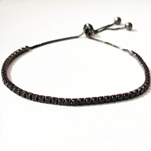 Macro shot of adjustable black tennis bracelet featuring dark cubic zirconia stones