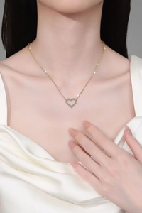 Détail du collier pendentif cœur avec micro-incrustations bleues sur cou de femme