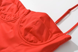 Détail d'une robe d'été rouge avec bretelles réglables et texture de tissu lisse