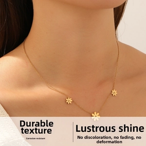 Detail view of a gold-plated daisy pendant necklace on a model showing daily wear style