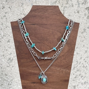 Detail of bohemian layered necklace set with turquoise beads and cactus pendant