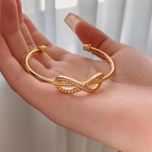 Macro shot of gold plated infinity bow bracelet with shimmering micro-set zircons