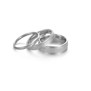 Detailed shot of three silver stainless steel rings with polished and frosted matte textures