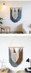 Detail of bohemian woven wall tapestry featuring colorful tassels on white brick background
