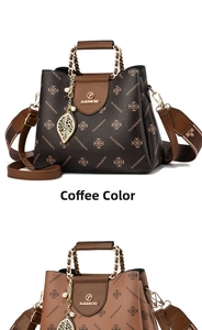 Close-up of contrast color handbag with gold chain handle and pearl leaf pendant details