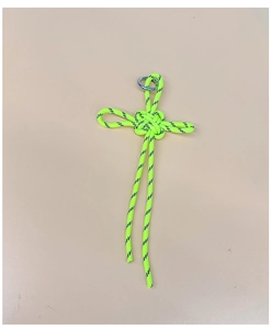 Macro shot of neon yellow handmade woven parachute cord cross pendant with metal ring