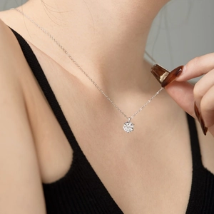 Elegant S925 sterling silver necklace featuring a brilliant round solitaire pendant on a woman