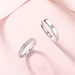 Elegant S925 sterling silver couple rings with sparkling diamonds on a soft pink fabric