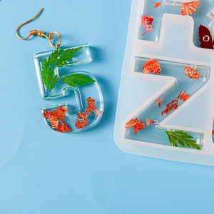 Detail von Harz-Ohrring Nummer 5 mit Blatteinlagen und Silikonform für Buchstaben