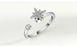 Detailed macro shot of a silver spinner ring featuring a sparkling star and round gemstone