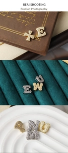 Detailed view of cubic zirconia alphabet pendants in gold and silver finish options