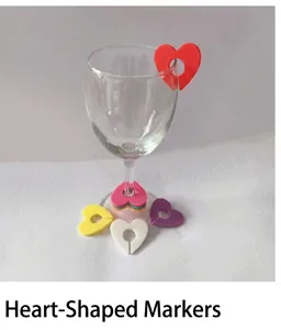 Macro shot of red heart silicone wine glass markers on the edge of a crystal goblet