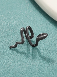 Dettaglio di un ear cuff a forma di serpente nero su una superficie strutturata