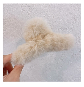 Close-up of fluffy beige plush hair claw clip showing soft faux fur texture