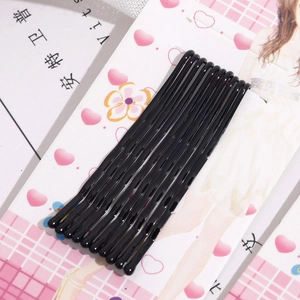 Close-up of 10 black wavy metal hair pins neatly arranged on decorative card packaging