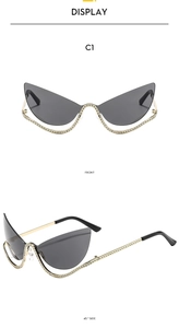 Detail view of gold cat-eye sunglasses with rhinestone edges and dark grey lenses